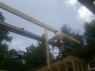 Carpenter setting a ridge beam over a new addition frame — Ice Dam Removal by Roofing Brothers in Mount Hood Parkdale