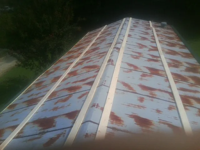 Rusted metal roof panels with new wood purlins before replacement — Storm Damage Roof Repair in Mount Hood Parkdale by Roofing Brothers