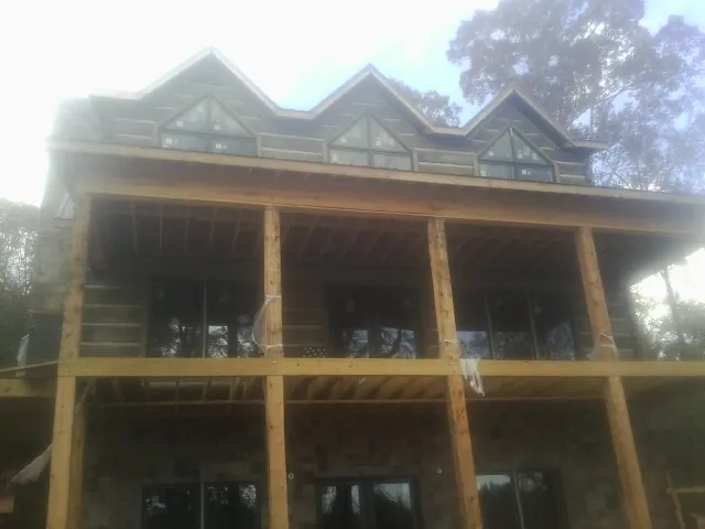 Dormers and porch framing on a large log home under construction — Roof Coating work by our crew in Mount Hood Parkdale