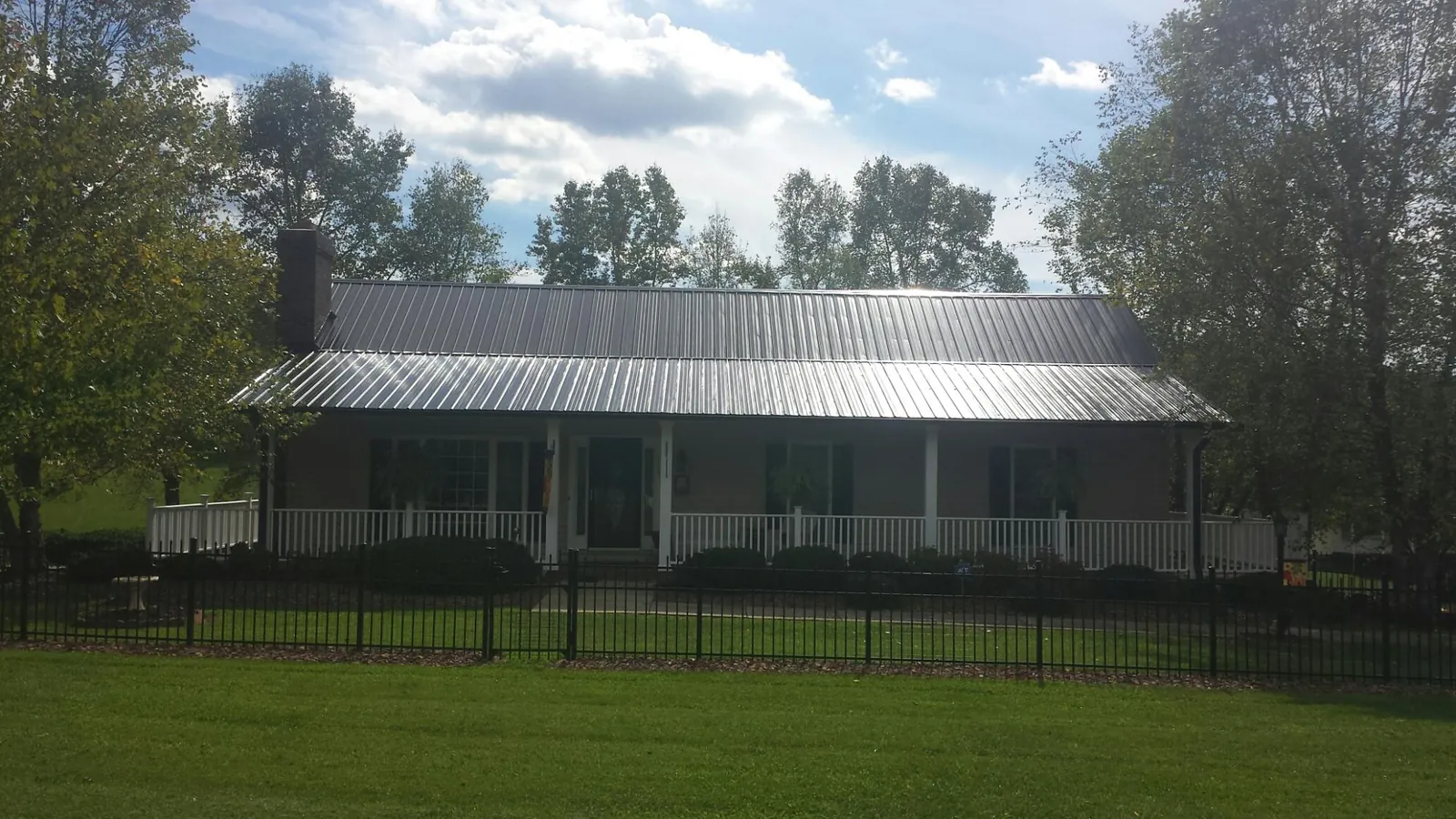 Gray metal roof on a brick ranch with a full width front porch — Gutter Guard Installation work by our crew in Mount Hood Parkdale