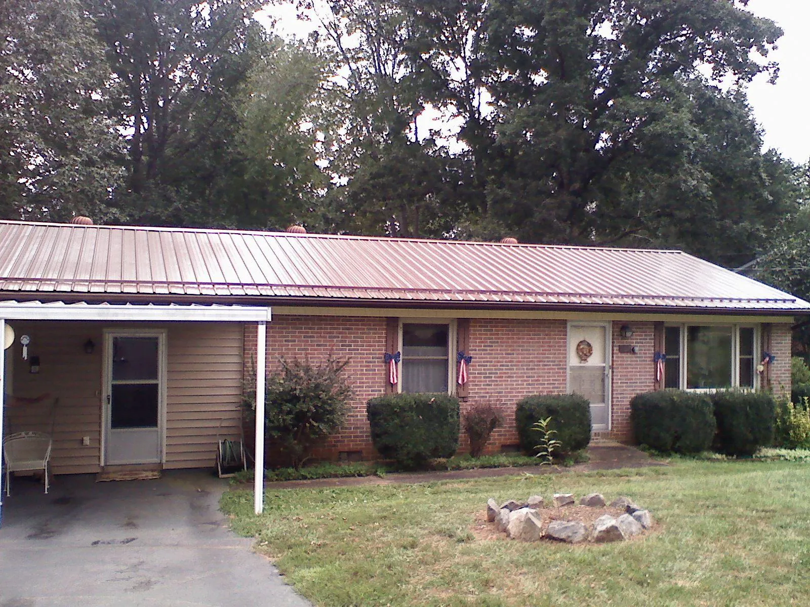 Bronze metal roof and carport on a brick ranch home — Roof Repair work by our crew in Mount Hood Parkdale